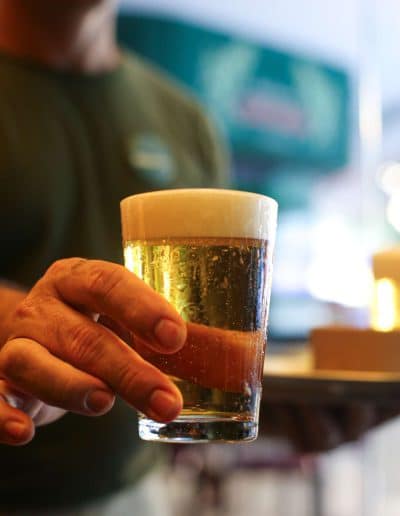 Academia waiter holding a draft beer.